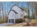 Charming two-story home with white stucco, black trim, a driveway, and a two-car garage at 3536 Evans Ridge Trl, Atlanta, GA 30340