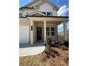 Inviting front porch with brick columns and a black front door at 317 Lavender Ln, Holly Springs, GA 30115