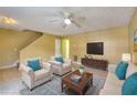 Bright living room features a ceiling fan, and comfortable seating, enhanced by a blue accent rug at 2878 Norfair Loop, Lithonia, GA 30038