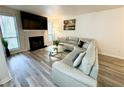 View of the living room featuring a fireplace, large sofa, and gray wood floors at 4079 Woodridge Way, Tucker, GA 30084