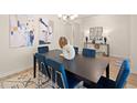 Contemporary dining room featuring a black wood table with blue chairs and modern artwork at 2712 Sw Riverpine Lot 175 Sw Trl, Atlanta, GA 30331