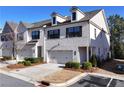 White brick townhome with two-car garage, nice landscaping, and driveway at 3532 Amarath Ter, Duluth, GA 30096