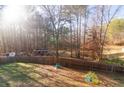 Large, fenced backyard with play equipment and a wooded backdrop, ideal for outdoor activities at 1620 Palm St, Canton, GA 30115
