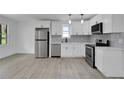 Modern white kitchen with stainless steel appliances and gray flooring at 1318 Graymont Sw Dr, Atlanta, GA 30310