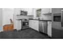 Modern kitchen with white cabinets, stainless steel appliances, and dark countertops at 1386 Sandy Ln, Decatur, GA 30032