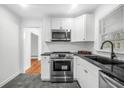 Modern kitchen with white cabinets, stainless steel appliances, and dark countertops at 1386 Sandy Ln, Decatur, GA 30032