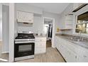 Galley kitchen featuring stainless steel appliances, white cabinets, and neutral countertops at 1405 Pinehurst Sw Dr, Atlanta, GA 30311