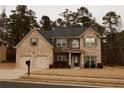 Two-story brick home with a large driveway and landscaped yard at 12298 Centerra Dr, Hampton, GA 30228