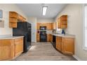 Functional kitchen features wood cabinets, black appliances, and laminate countertops with durable flooring at 2555 Flat Shoals Rd # 802, Atlanta, GA 30349
