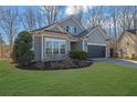Attractive home featuring a two-car garage, manicured landscaping, and a vibrant green lawn at 3490 Buffington Ln, Cumming, GA 30040
