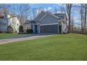 Well-maintained home with lush green lawn and a paved driveway leading to a two-car garage at 3490 Buffington Ln, Cumming, GA 30040