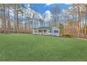 Inviting single-story home with a lush front lawn, framed by mature trees offering privacy and a serene outdoor space at 369 Antioch Rd, Dallas, GA 30157