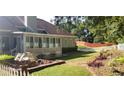 Well-maintained backyard with white picket fence, patio seating area, and beautiful landscaping at 2509 Fairweather Ct, Conyers, GA 30013
