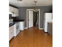 White kitchen cabinets, laminate floors, and appliances at 3592 North St, Duluth, GA 30096