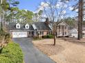 Traditional brick home with an attached garage, surrounded by mature trees and a paved driveway at 1579 Howell Highlands Dr, Stone Mountain, GA 30087