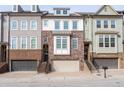 Three-story townhome with brick and siding exterior, two-car garage, and front steps at 2134 Old Georgian Nw Ter, Atlanta, GA 30318