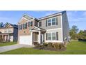 Two-story house with gray and brick exterior, landscaping, and a driveway at 1508 Denver Way, Locust Grove, GA 30248