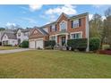 Brick house with a two-car garage and landscaping, situated on a spacious lot at 615 Keeneland Ter, Woodstock, GA 30189