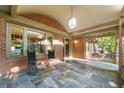 Relaxing covered porch features brick columns, slate flooring, rocking chairs, and plenty of natural light at 2220 Edison Ave, Atlanta, GA 30305