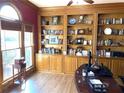 Well-lit home office with built-in wooden bookshelves, desk, and large window at 5440 Cameron Forest Pkwy, Johns Creek, GA 30022