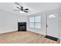 Bright living room with fireplace, hardwood floors, and ceiling fan at 2918 Fields Dr, Lithonia, GA 30038