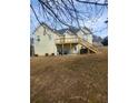 Exterior of home featuring a spacious backyard and a wooden deck with stairs at 633 Herron Ct, Fairburn, GA 30213