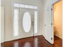 Bright foyer featuring hardwood floors, a front door with sidelights, and a coat closet at 633 Herron Ct, Fairburn, GA 30213