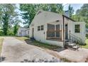 White brick house with gray porch and steps, surrounded by green trees at 265 Whitaker Nw Cir, Atlanta, GA 30314