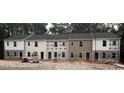 Row of three-story townhouses under construction, showcasing a blend of neutral colors at 7240 Crestside Dr, Austell, GA 30168