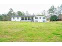 Ranch-style home with a white exterior, a covered front porch, and a spacious front yard with mature trees at 218 Ward Rd, Ellenwood, GA 30294