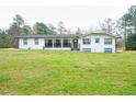 Charming home with a large front lawn, covered porch, and a freshly painted white exterior at 218 Ward Rd, Ellenwood, GA 30294
