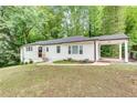 White ranch home with mature trees and a carport at 2705 Baker Ridge Nw Dr, Atlanta, GA 30318