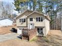 Tan two-story house with attached garage and deck at 5737 Riverside Dr, Sugar Hill, GA 30518