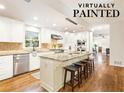 White kitchen with granite island, stainless steel appliances, and hardwood floors at 1195 Old Woodbine Rd, Atlanta, GA 30319