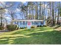 Ranch style home with blue exterior, pink door, and spacious lawn at 4086 Pecan Nw Ct, Lilburn, GA 30047