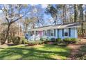 Charming ranch home with light blue exterior and lush landscaping at 4086 Pecan Nw Ct, Lilburn, GA 30047