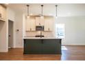 Modern kitchen with island, pendant lights, and sleek appliances creating an elegant cooking space at 261 Dahlia Dr, Woodstock, GA 30188