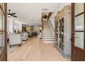 Inviting foyer with wood floors, staircase, and decorative cabinet showcase at 5247 Flannery Chase Sw, Powder Springs, GA 30127