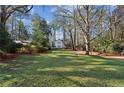 Large grassy yard with mature trees and a view of the house at 2460 Oldfield Rd, Atlanta, GA 30327