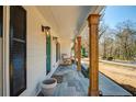 Spacious front porch with wood columns, stylish lighting fixtures, and comfortable rocking chair at 2622 Marcia Dr, Lawrenceville, GA 30044