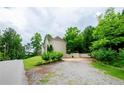 Gravel driveway leading to a home nestled in trees at 2120 Shaffer Rd, Cumming, GA 30041