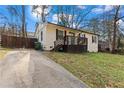 Exterior view of home with painted brick, a quaint porch, driveway, and partial fenced yard at 2409 Swallow Se Cir, Atlanta, GA 30315