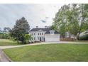 Beautiful home featuring a manicured lawn, mature trees and a three-car garage, creating an inviting curb appeal at 1901 Shelburne Cv, Marietta, GA 30068