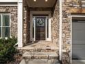 Stone front porch with a dark wooden door and wreath at 2012 Mendenhall Cir, Atlanta, GA 30341