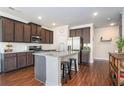 Well-lit kitchen with stainless steel appliances, a large island, and dark wood cabinets at 366 Cherryhill Ln, Woodstock, GA 30188