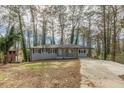 Newly renovated ranch home with gray brick exterior, modern porch, and long driveway at 1707 Boulderview Se Dr, Atlanta, GA 30316