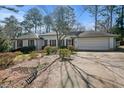 House exterior showcasing a large driveway and mature trees at 450 Knoll Woods Dr, Roswell, GA 30075