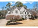 Gray house with landscaping, stone accents, and driveway at 550 Bircham Way, Roswell, GA 30075