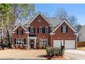 Two-story brick home with a two-car garage and mature trees at 115 Parkside Close, Alpharetta, GA 30022