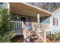 Inviting front porch with wooden swing and string lights at 215 Silver Creek Ln, Stockbridge, GA 30281